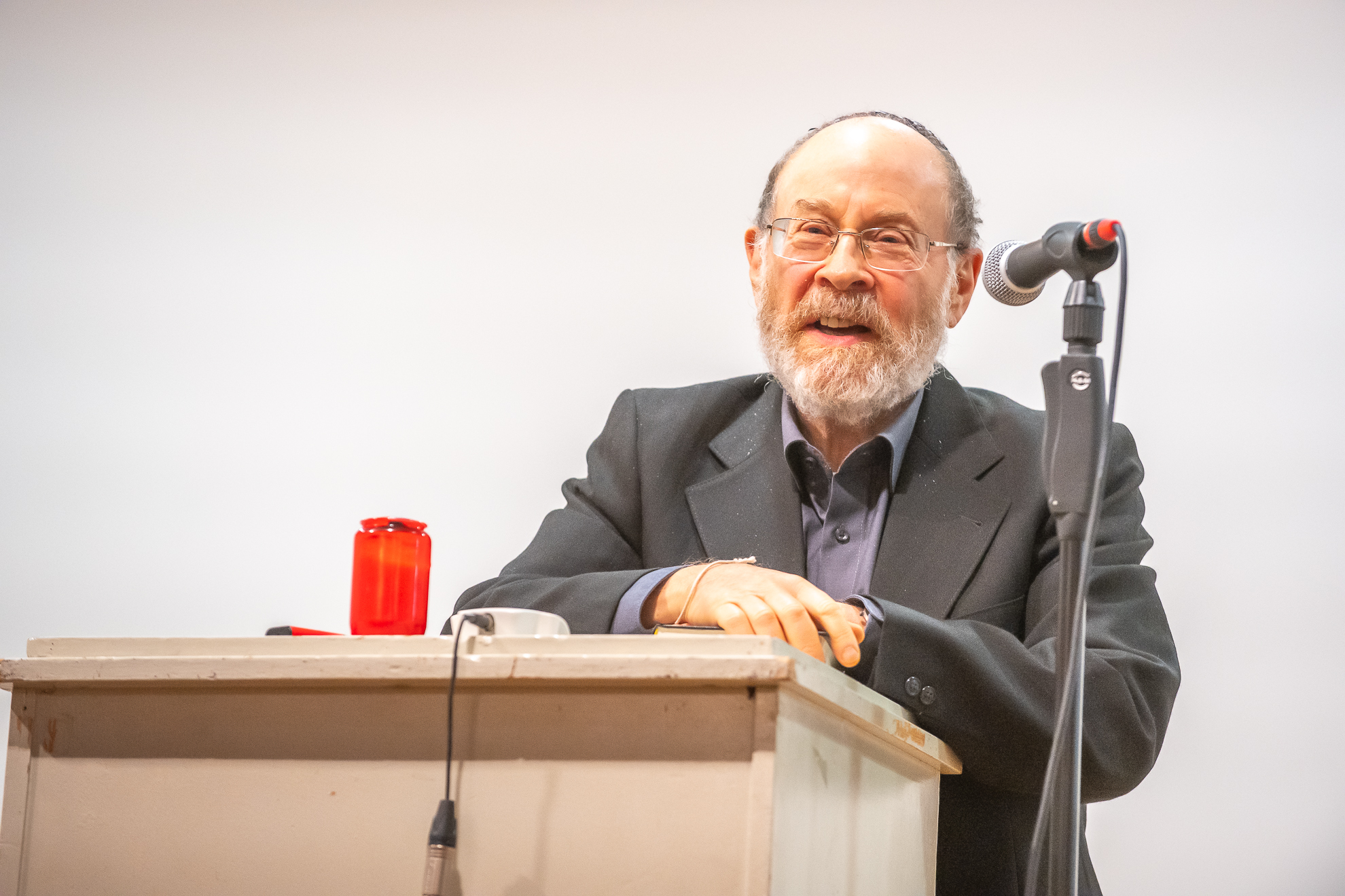 Rabbiner Andrew Steiman steht an einem Stehpult und spricht in ein Mikrofon.